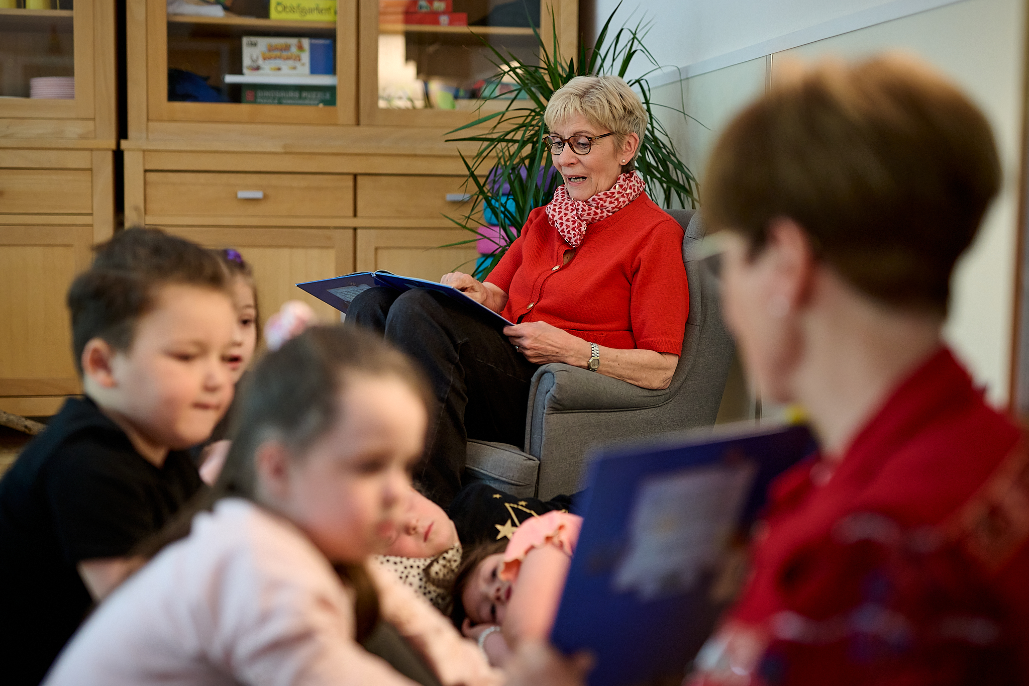 Eine Erzieherin liest Kindern vor.