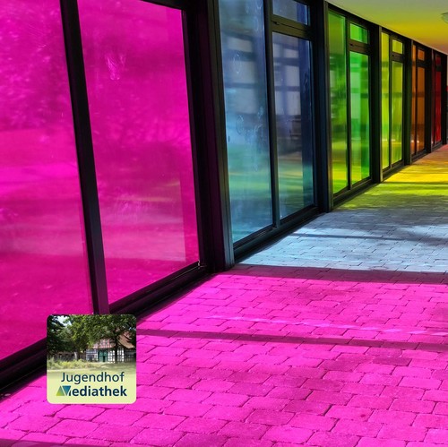 Das Foto zeigt den Sonnenlichteinfall durch die farbigen Fenster. Auch der Fußboden färbt sich durch das Licht regenbogenfarben.