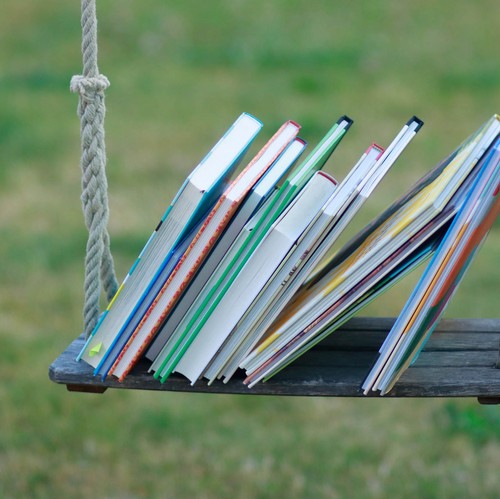 Das dekorative Foto zeigt Bücher, auf einer Schaukel liegend.