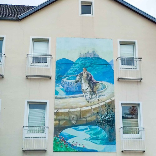 Foto einer Hausfassade, die durch ein überdimensionales Gemälde eines reitenden Ritters mit Lanze geziert wird